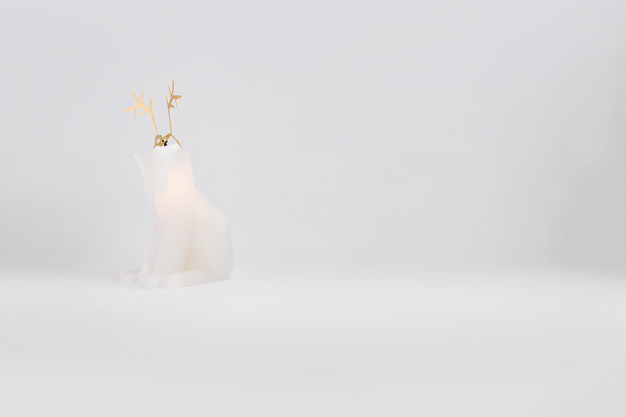 Side view of white dyri reindeer pyropet candle. Burn it to reveal the skeleton frame inside. 