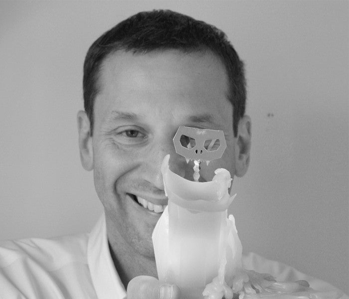Dan Koval of 54 Celsius holding a burning kisa the cat pyropet candle. As it burns it reveals skeleton frame. 
