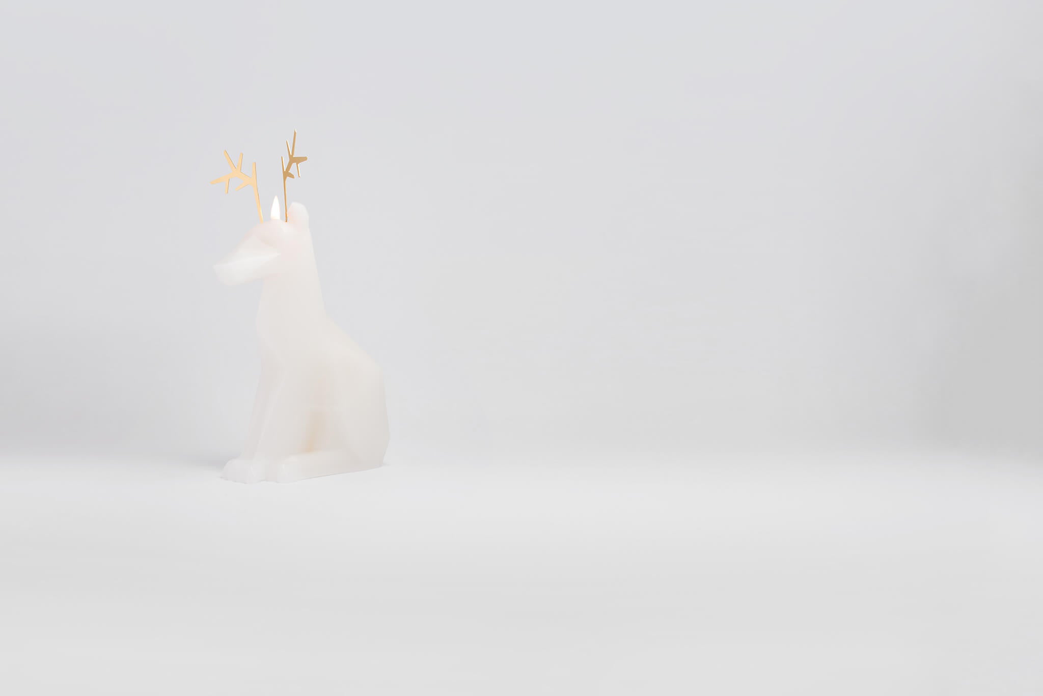 Side view of white dyri reindeer pyropet candle. Burn it to reveal the skeleton frame inside. 